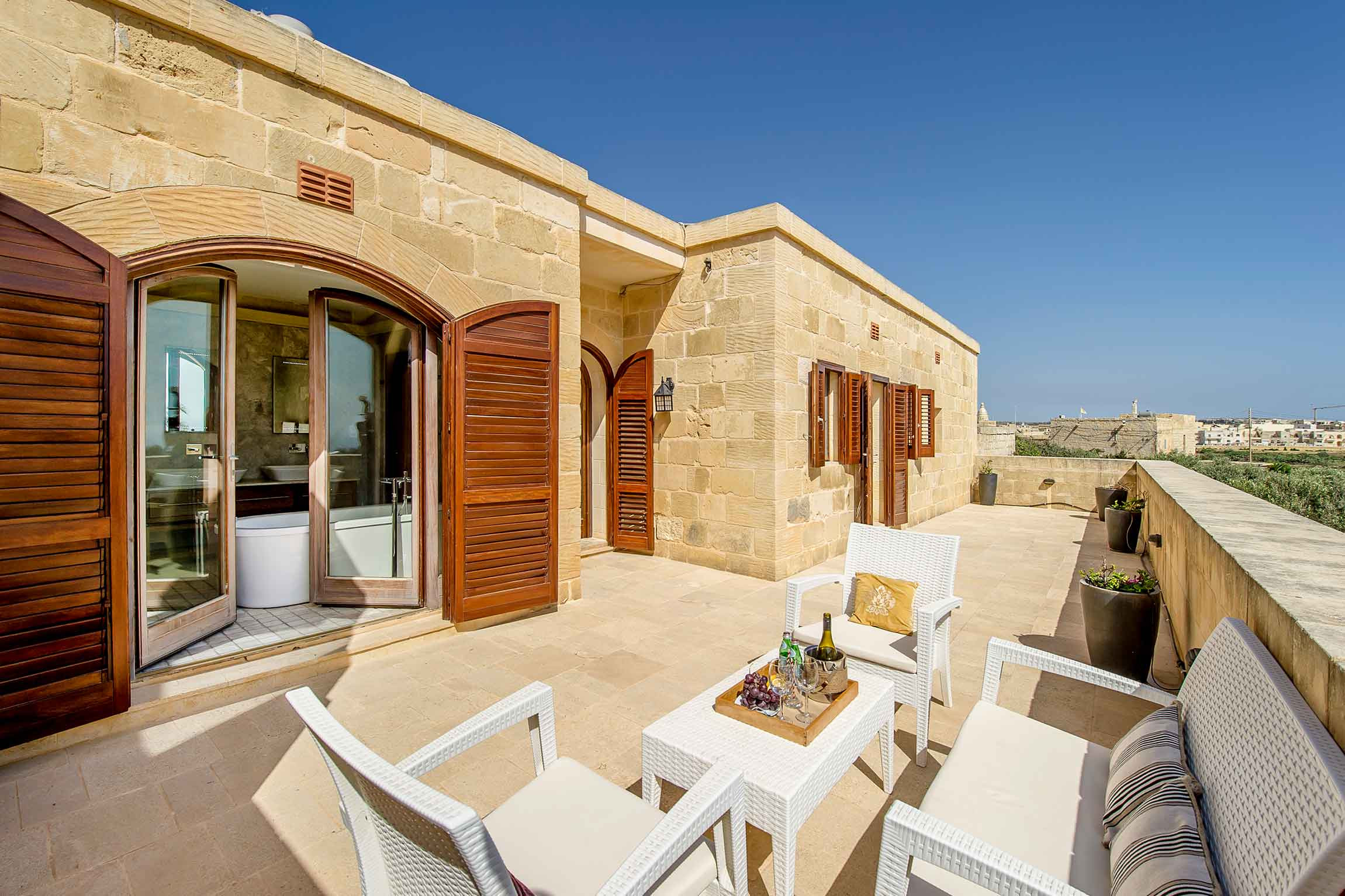 Sonnige Terrasse eines maltesischen Landhauses mit Natursteinfassade