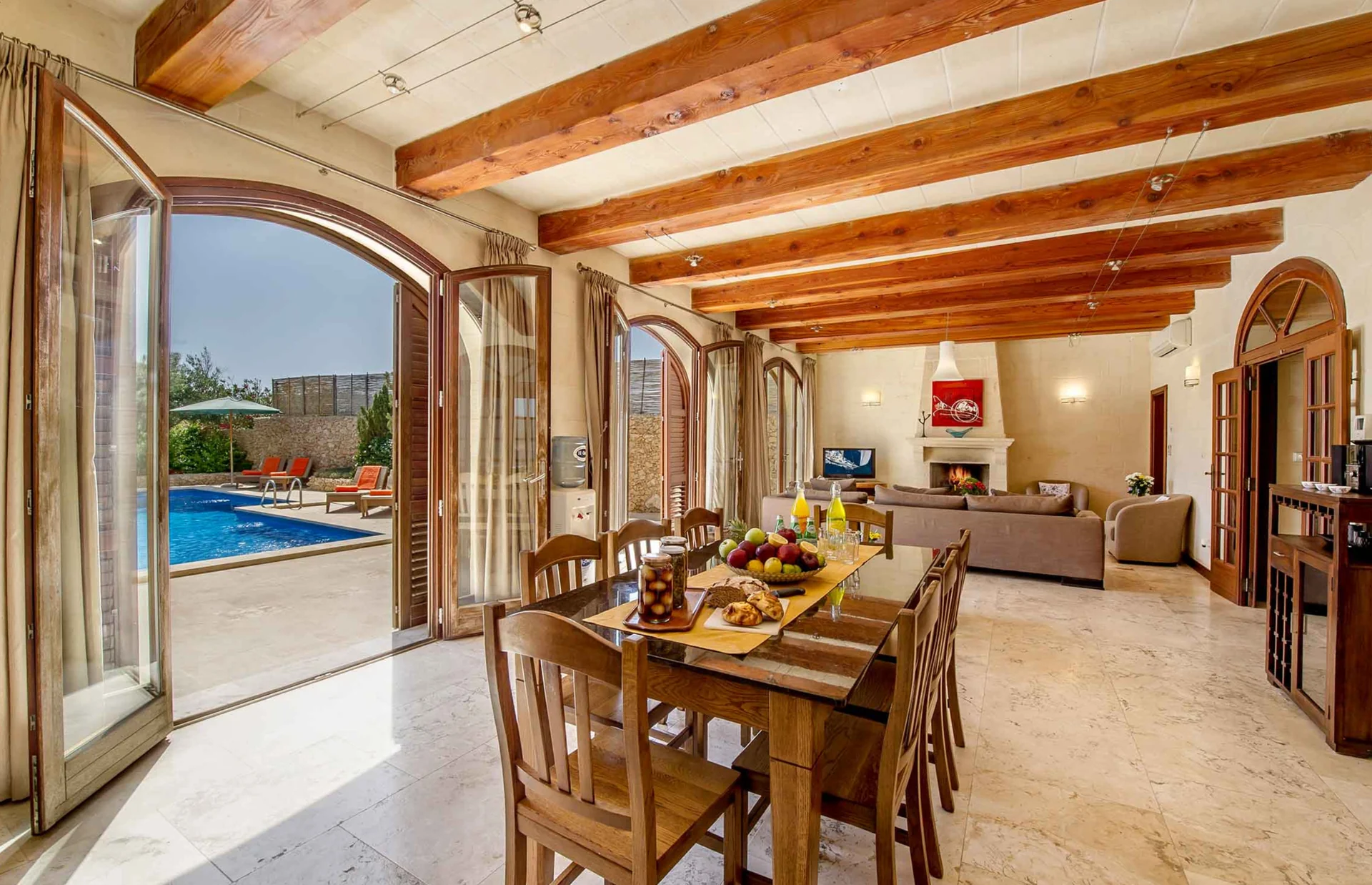 Wohn- und Essbereich der Unterkunft auf Malta mit Blick zum Pool